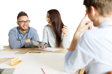 Three colleagues collaborating at a desk, one holding a tablet, on a white background. Focused on teamwork and brainstorming concepts