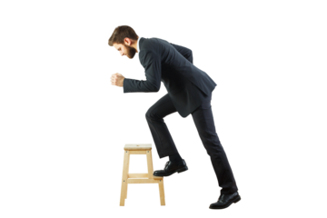 A man in a business suit confidently stepping on a wooden stool. Isolated on a white background. Concept of progress, growth, and success