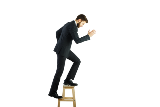 Businessman in formal attire stepping on a stool, isolated on white background. Concept of ambition, career growth, and success