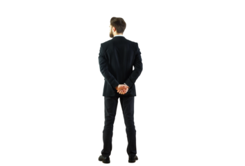 Man in formal business attire standing with hands behind back, isolated on white background. Concept of professionalism and confidence
