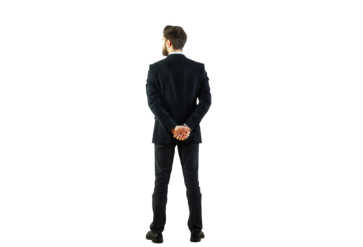 Man in formal business attire standing with hands behind back, isolated on white background. Concept of professionalism and confidence