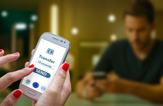 Close-up of hands using a smartphone to initiate an online money transfer, with a countdown timer showing transaction processing time. Concept the Instant Payments Regulation tand Ensuring euro money