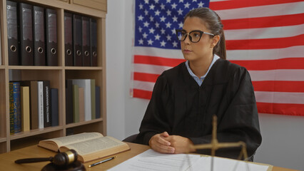 Woman judge sitting in office with american flag background, surrounded by books and documents,...