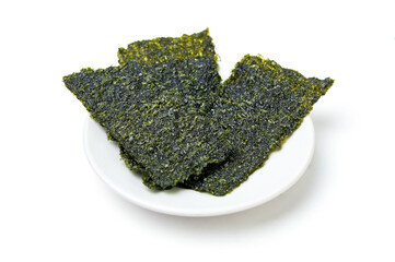 Crispy fried seaweed place on white dish isolated on white background. Algae are plants that grow in lakes, rivers, and other bodies of water. Seaweed has many benefits and is a snack for weight loss.