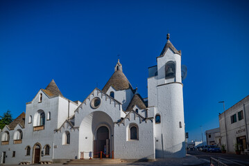 Paisaje urbano con increíble arquitectura típica de truli con hermosos tejados iluminados por el sol en la región de Puglia, cerca de la ciudad de Alberobello, en el sur de Italia. Cálida mañana de ve