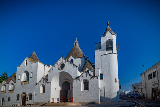 Paisaje urbano con incre&iacute;ble arquitectura t&iacute;pica de truli con hermosos tejados iluminados por el sol en la regi&oacute;n de Puglia, cerca de la ciudad de Alberobello, en el sur de Italia. C&aacute;lida ma&ntilde;ana de ve