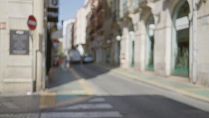 Obraz premium Defocused street scene in a european city with a blurred background featuring buildings and a car on a bright, sunny day with bokeh effect.