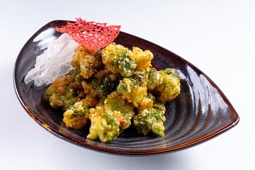 Deep-Fried Vegetables on a Plate Against a White Background