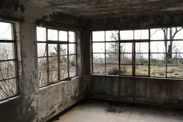 Abandoned mansion interior with broken windows.