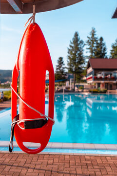 Red lifeguard float on a summer afternoon in an empty pool