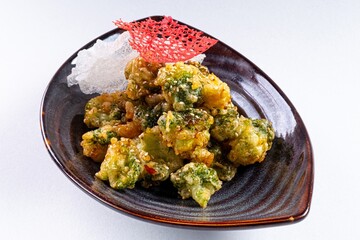 Deep-Fried Vegetables on a Plate Against a White Background