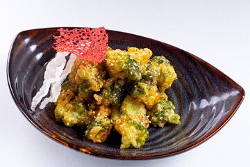Deep-Fried Vegetables on a Plate Against a White Background