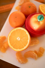 fresh oranges on white plate at yellow background