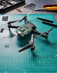 Partially Assembled Racing Drone on Workbench with Tools and Spare Parts