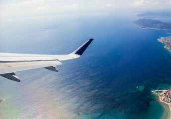 Fototapeta premium n airplane wing with clear blue sky background flying above Greek islands