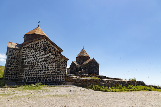 Sevanavank monastery majestically overlooks Lake Sevan, showcasing its ancient architecture against a blue sky.