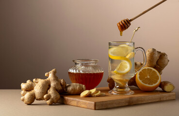 Ginger tea with lemon and honey on a beige background.