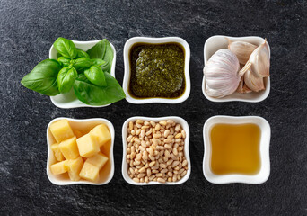 Traditional Italian pesto recipe on a dark stone background.