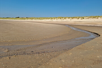 Water flowing from sandy beach at low tide, Zeeland, Netherlands