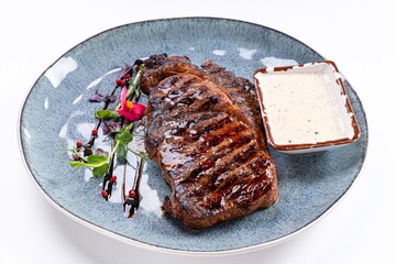Huge Juicy Steak with Sauce on a Plate on a White Background