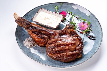 Huge Juicy Steak with Sauce on a Plate on a White Background