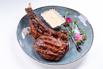 Huge Juicy Steak with Sauce on a Plate on a White Background