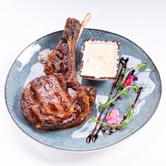 Huge Juicy Steak with Sauce on a Plate on a White Background