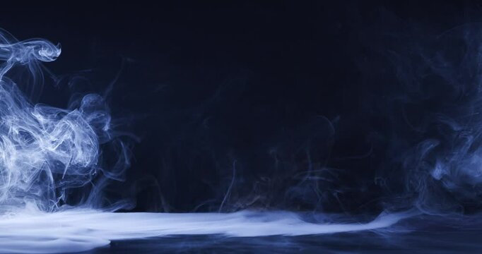 Abstract image of dark room concrete floor. Black room or stage background for product placement.Panoramic view of the abstract fog. White cloudiness, mist or smog moves on black background. 