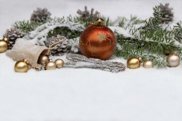 Winterlicher Weihnachtshintergrund: Weihnachtskugeln und Tannenzweige im Schnee mit Textfreiraum.	