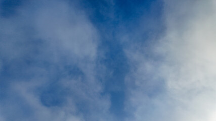 Obraz premium A serene blue sky filled with fluffy clouds, symbolizing tranquility and the beauty of nature on a clear day