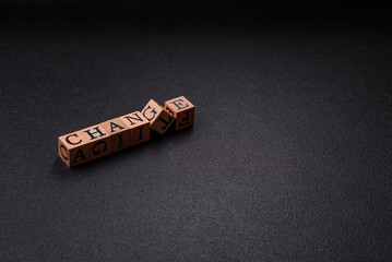 The inscription chance or change with wooden cubes on a dark concrete background