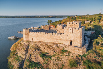 Naklejka premium The historical castle of Ram stands as a remarkable landmark, with its well-preserved fortifications and towers set against a summer sunset over Danube river, Serbia
