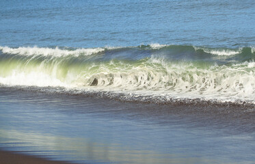 a wave breaking on a beach on the coast of Chile