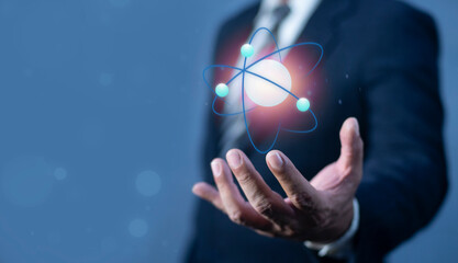 Bussinessman hand holding molecule of an atom. Nuclear fusion concept, endless energy, cheap...