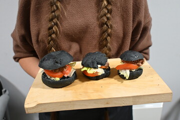 Girl Cooking Black Buns For Burger