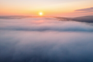 Incredible dawn, the sun rises above the low fluffy clouds that enveloped the earth.