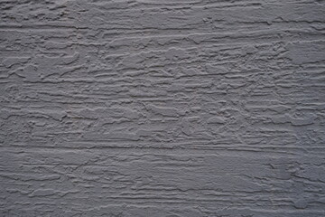A closeup photograph of a beautifully textured gray wall that showcases intricate patterns and its depth