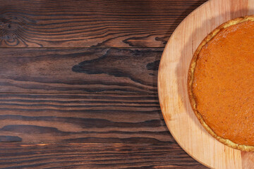 Fototapeta premium Pumpkin Pie on Rustic Wooden Background with Empty Space