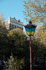 Alte Straßenlaterne in Blau und Gelb, den Farben der Ukraine, im Herbst bei Sonnenschein an der...