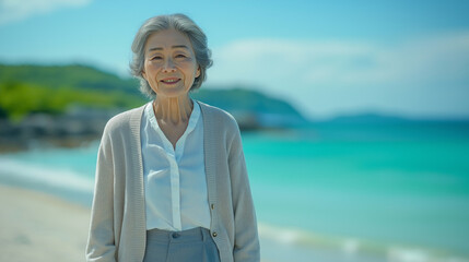 Fototapeta premium 海岸を散歩するシニア女性