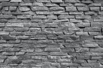 Obraz premium Rough stone wall made of ceramic tiles of different sizes and colors: black and white texture.