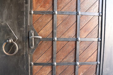 Elegant Wooden Door with intricate Iron Detailing and a Knocker for added appeal