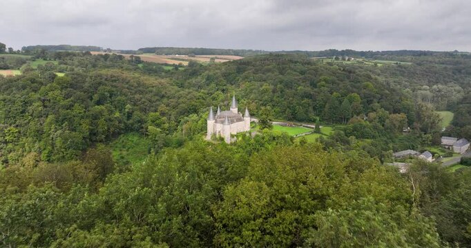 Drone shot over The Castle of Veves with green landscape and hills