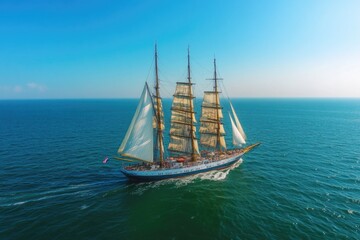 Obraz premium A sailboat gliding through the open ocean, blue waters and white foam