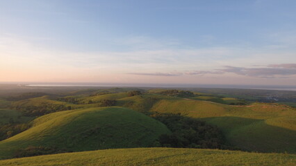 green rolling hills leading to ocean