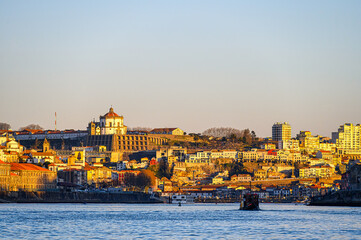 Cityscape by the waterfront district, featuring a vessel moving in the Douro River