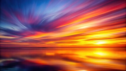 Fototapeta premium A vibrant, colorful sunset over a tranquil body of water, the sky ablaze with streaks of orange, pink, and purple hues, reflecting beautifully in the serene water.