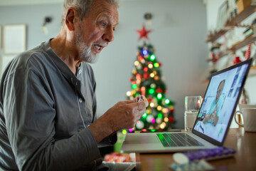 Senior man having virtual medical consultation during Christmas