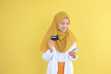 Asian Young Muslim Female Holding Credit Card and Mobile Phone