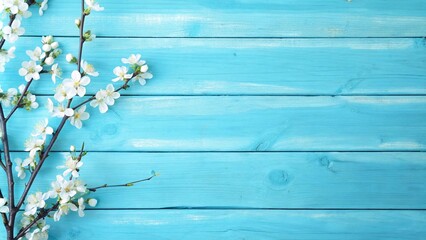 Fototapeta premium White blossoms on a vibrant blue wooden backdrop, creating a cheerful spring atmosphere ideal for text or promotional use.